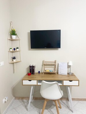 Enjoy a functional space with a flat-screen TV, desk, and shelving unit.