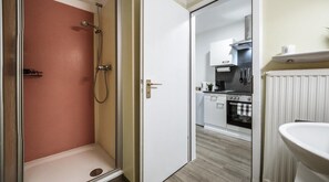 A bathroom with a shower, toilet, and sink.