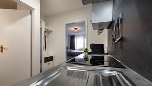 A modern kitchen with a sleek countertop, a built-in stove, and a coffee machine.