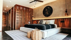Een moderne slaapkamer met een groot bed, houten paneelbekleding, een plafondventilator en een wandlamp.