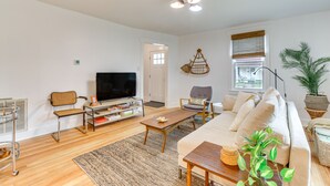 Ein modernes Wohnzimmer mit Sofa, Couchtisch, Fernseher und Bücherregal.
