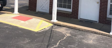 A building with a 'VACANCY' sign, a door labeled 'OFFICE', and a 'WELCOME' mat.