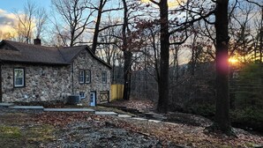 Una casa in pietra con tetto spiovente, un'entrata e un piccolo portico.