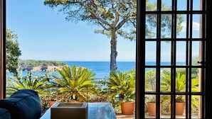 A room with a view of the sea, a large window with a view of the sea, and a table with a laptop. - Maset CostaBravaSi - with pool, views, parking (Sant Feliu de Guíxols)