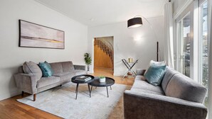 A modern living room with two grey sofas, a coffee table, and a large window. - Luxurious House Big Terrace | Sleeps 16 | 3bath (Montréal)