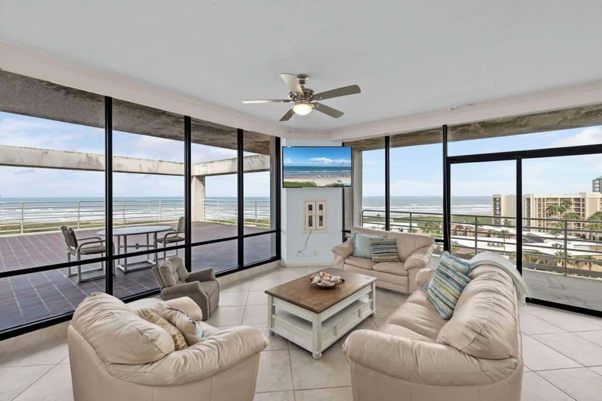 A spacious balcony with a view of the ocean and cityscape.