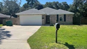 A single-story house with a garage, a front yard, and a mailbox.