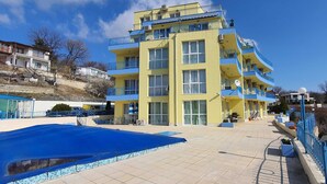Un immeuble à plusieurs étages doté de balcons, d’une piscine et d’un patio couvert.