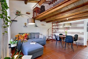 A modern living room with a sofa, dining table, chairs, and a staircase. - Campo de Fiori - Rome, nice apartment with terrace for 6 people (Roma)
