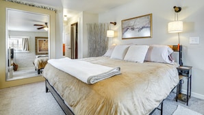 A bedroom with a large bed, a ceiling fan, a wall-mounted lamp, and a framed artwork. - New Mexico Cottage: Private Yard & Hot Tub (Truth or Consequences)