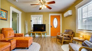 A living room with a ceiling fan, a television, and a fireplace. - New Mexico Cottage: Private Yard & Hot Tub (Truth or Consequences)