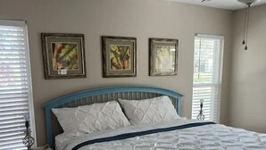 A bedroom with a bed, a nightstand, a ceiling fan, and three framed pictures on the wall. - Tropical Pool & Spa Home, 3/2, Near Disney, Universal, Sea World, Beaches (Altamonte Springs)