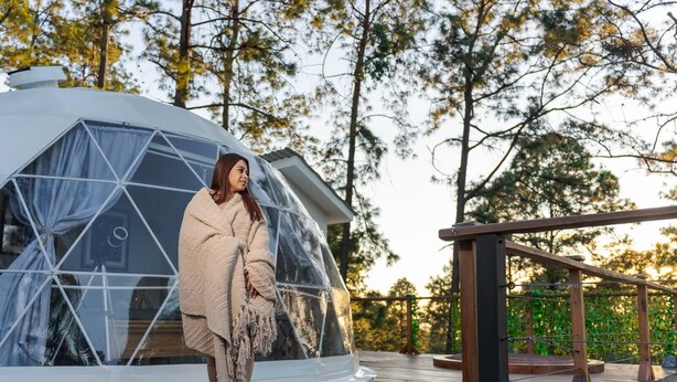 A geodesic dome structure with a wooden deck in front.