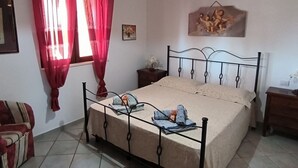 Une chambre à coucher avec un lit, des rideaux, une table de chevet, une lampe et un élément décoratif mural.