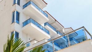 Un edificio de varios pisos con balcones y fachada blanca.