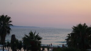 Vista de una playa con palmeras y un mar tranquilo.