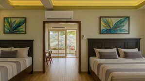 A hotel room with two beds, a dining table, and a view of a garden through a glass door. - Beach frontage Family Vacation home, 10 miles from downtown PV romantic zone (Boca de Tomatlán)