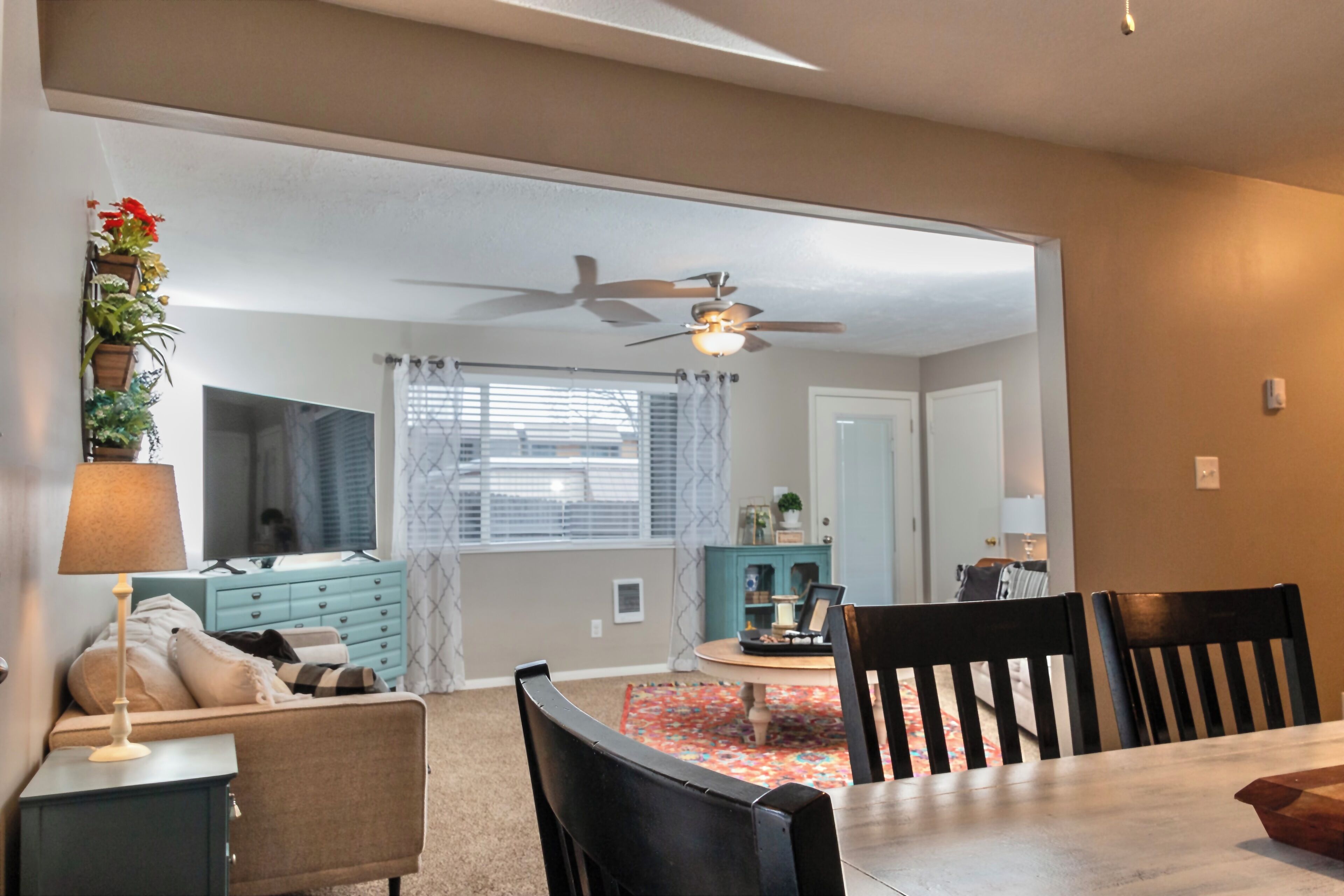 A dining area with a table, chairs, and a ceiling fan.