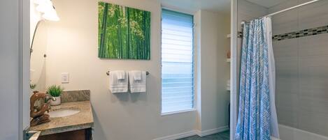 A bathroom with a sink, mirror, towel rack, and a shower curtain.