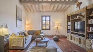 A cozy living room with a sofa, coffee table, and bookshelf.