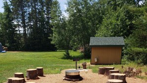 A rustic outdoor area with a fire pit surrounded by tree stumps. - Minutes from downtown Wisconsin Dells and sports and water parks.  (Wisconsin Dells)