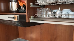 A kitchen with a stainless steel sink, a stove with two burners, and a dish drying rack above the sink. - Apartment by the sea with swimming pool (Porto Empedocle)