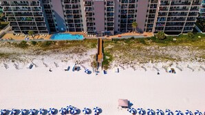 Ein mehrstöckiges Hotel mit Pool und Strand.