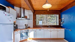 A modern kitchen with white cabinets, a stainless steel oven, and a window with a view of trees. - Awesome home in Talloires-Montmin (Talloires-Montmin)