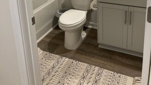 A bathroom with a toilet, a bathtub, and a sink. - Cozy townhome with 1 Brm with desk , 1.5 BA, Kitchen, in enjoyable Fuquay-Varina (Fuquay-Varina)