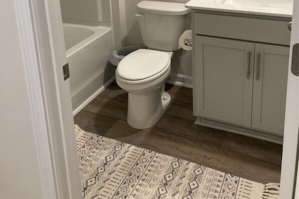 A bathroom with a toilet, a bathtub, and a sink.
