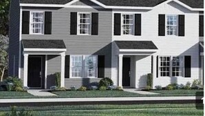 A modern two-story residential building with a symmetrical facade, multiple windows, and a well-maintained lawn. - Cozy townhome with 1 Brm with desk , 1.5 BA, Kitchen, in enjoyable Fuquay-Varina (Fuquay-Varina)