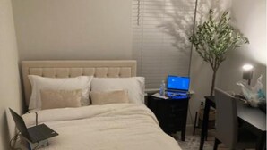 A neatly arranged bedroom with a bed, a laptop on the bed, a desk with a laptop, and a chair. - Cozy townhome with 1 Brm with desk , 1.5 BA, Kitchen, in enjoyable Fuquay-Varina (Fuquay-Varina)