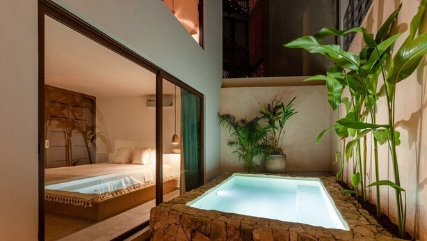 A spa area with a hot tub, a bed, and a potted plant. - Azalea 5 Condos 8BR 23 PPL  Private Pool (Tulum)