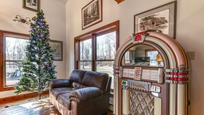 Ein Zimmer mit Weihnachtsbaum, Ledersofa und Jukebox.