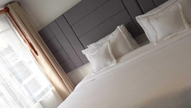 A modern hotel room with a large bed, grey headboard, and white bedding. - Hotel Boutique FC (Bogotá)