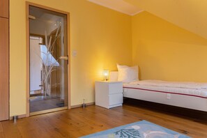 Un dormitorio con cama, mesita de noche y tocador.