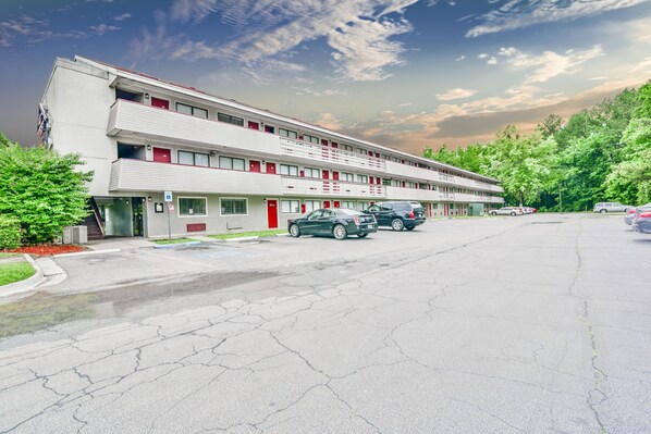 Un motel de dos pisos, con varias habitaciones y un estacionamiento.