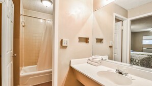 A bathroom with a bathtub, a sink, and a mirror. - Economy Hotel Atlanta   (Atlanta)