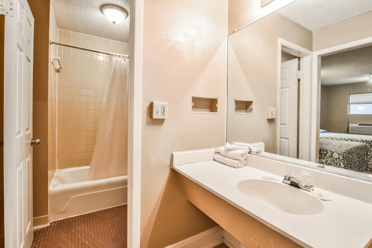 Un baño con bañera, lavamanos y espejo.