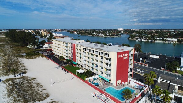 A hotel with a pool, located near a beach and water.