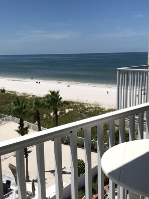 A balcony with a view of a beach and ocean.