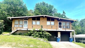 A two-story building with a flat roof, a front porch, and a garage.