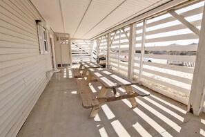 A covered outdoor area with picnic tables and a view of a parking lot. - Oceanside, Wild Horses! Beach getaway, remote location, 4x1701, Sandy Paws Retreat (Corolla)
