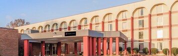 A hotel with a modern facade, featuring a series of arched windows and a prominent entrance with a covered walkway.