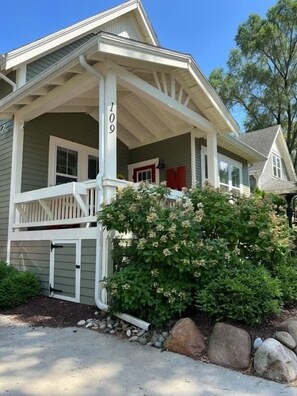A two-story house with a porch, a mailbox, and a number '109' on the side. - Modern Cottage "M" Luxury home w/hot tub, community pool-walk to town & beach (New Buffalo)