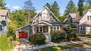A single-story house with a front porch, a garage, and a well-maintained lawn. - Modern Cottage "M" Luxury home w/hot tub, community pool-walk to town & beach (New Buffalo)