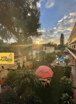 A hotel courtyard with a pool, outdoor seating, and a sign for Hotel Plateados. - HOTEL PLATEADOS OAXTEPEC (Yautepec)