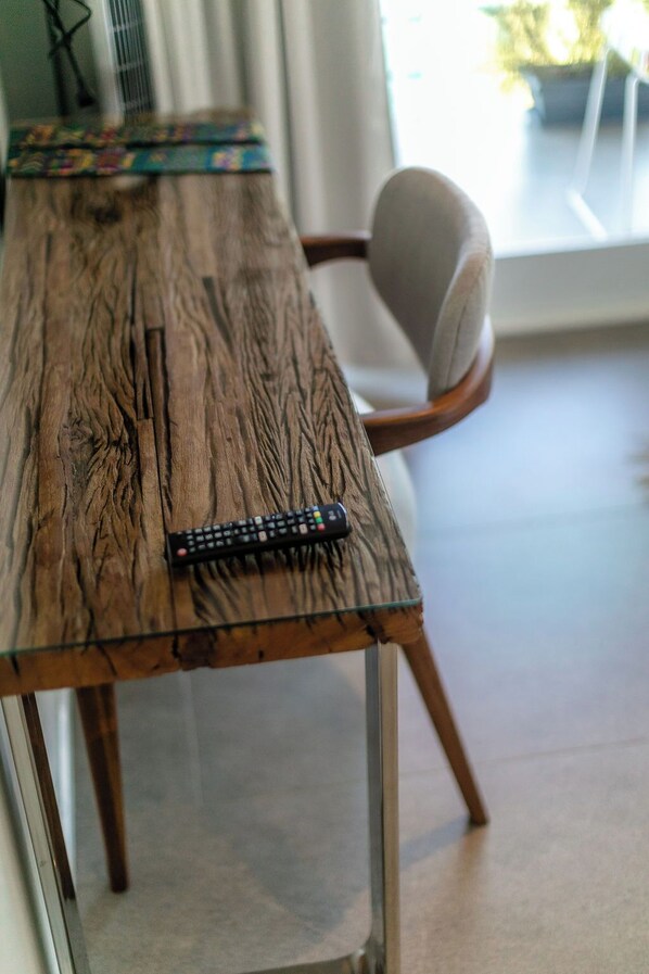 A wooden table with a remote control on it.