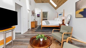 A modern bedroom with a large bed, a television, and a wooden ceiling. - Amazing Views / Hot Tub / 15 mins to Wineries / 3200 sq ft (Wintergreen Resort)