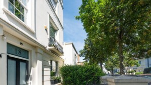 Un immeuble à plusieurs étages, doté d’une façade blanche, de fenêtres numérotées et d’un balcon.